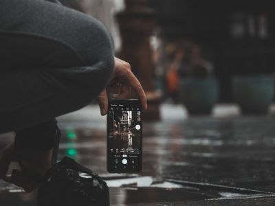 内容创作者工作台前手机拍摄的短视频素材正在导入电脑剪辑软件，屏幕冷光与键盘特写，专业氛围